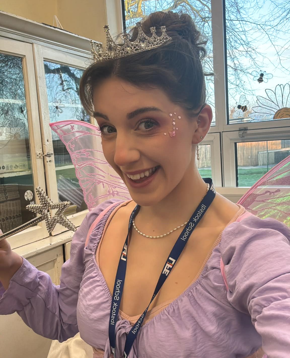 Francesca dressed as Titania, queen of the fairies, with a tiara, sparkles, and a wand